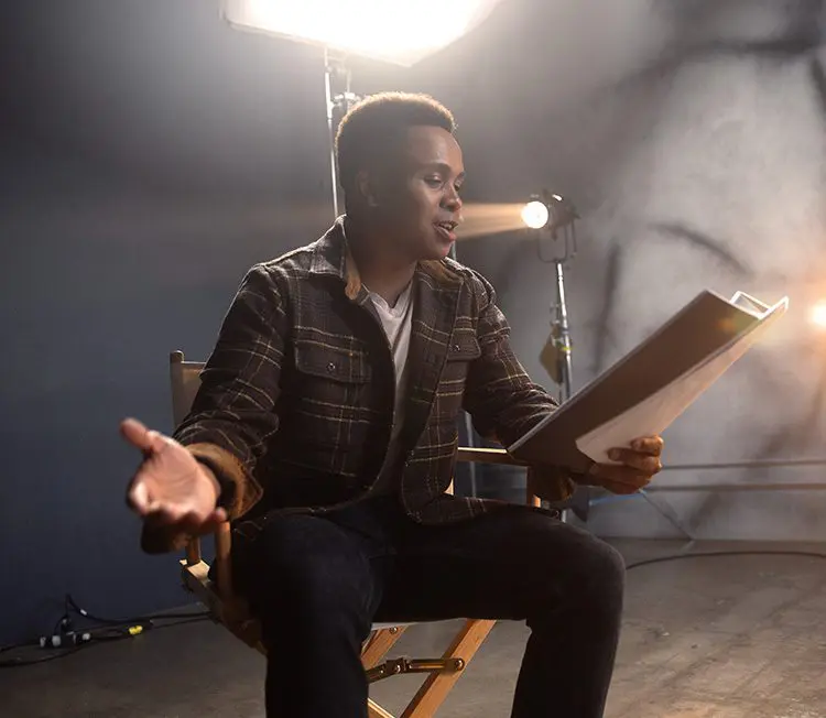 A young performer reads from a script.