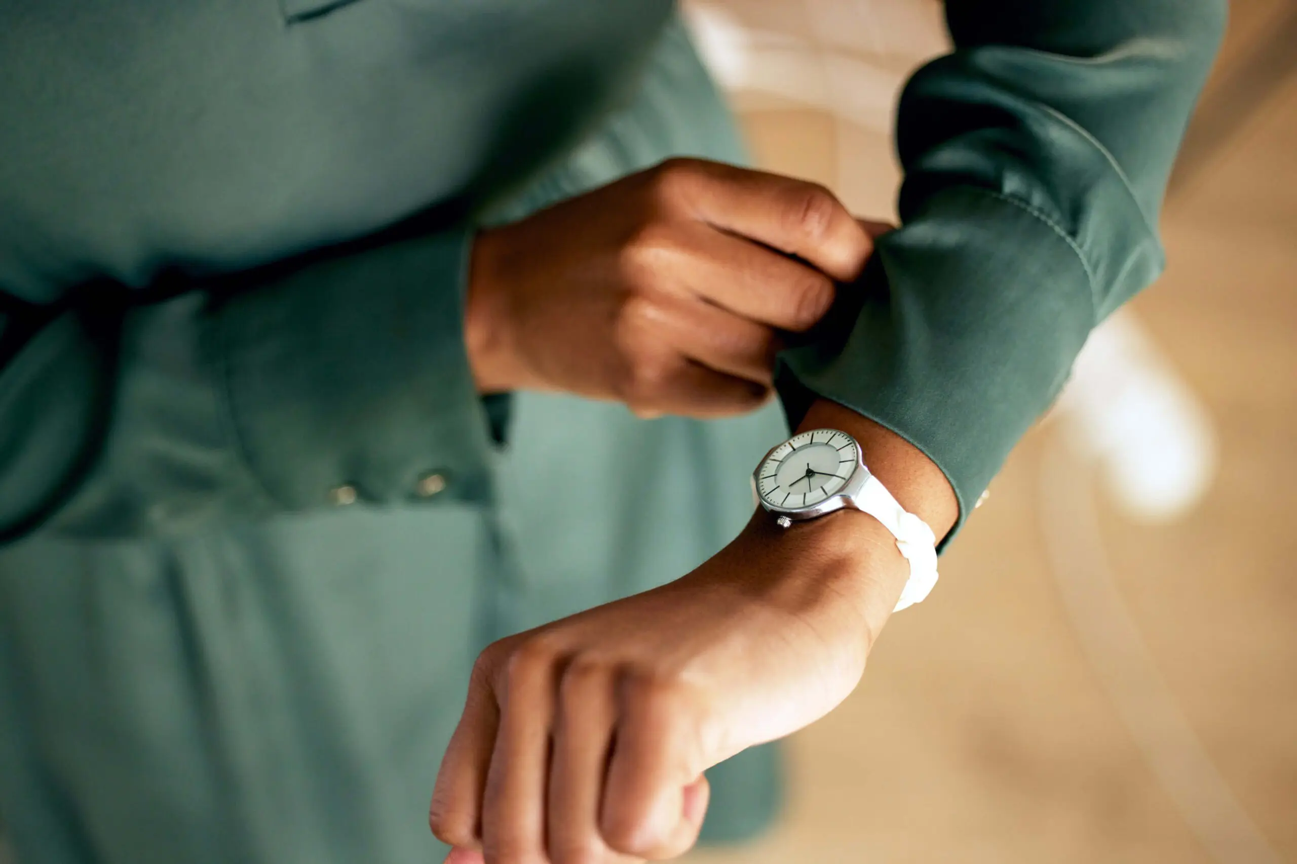 Actress wearing green looking at her watch to check the time