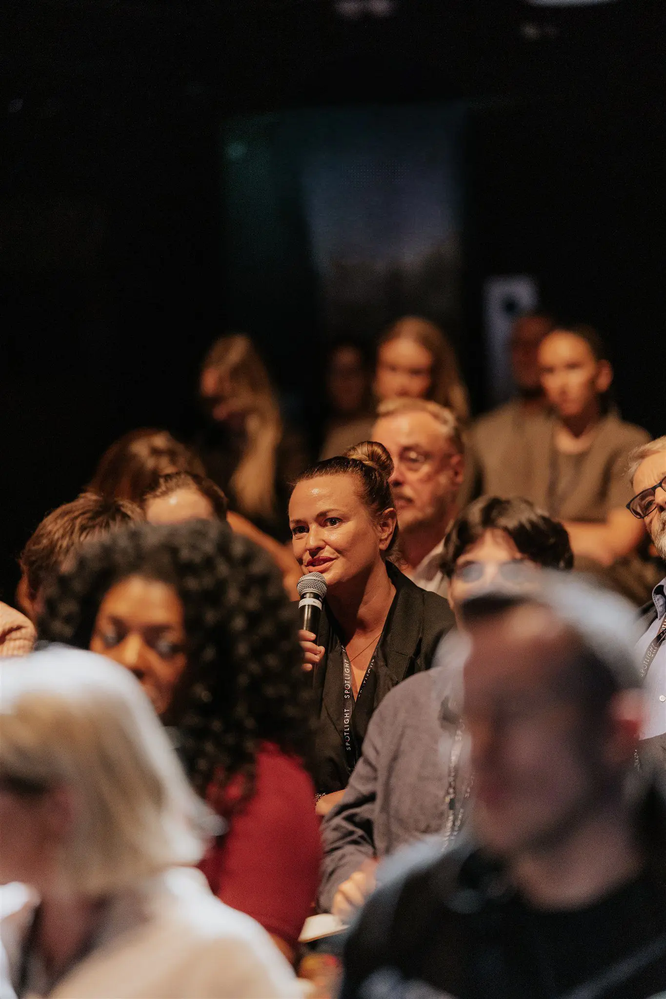 Crowd of people with a lady holding a mic