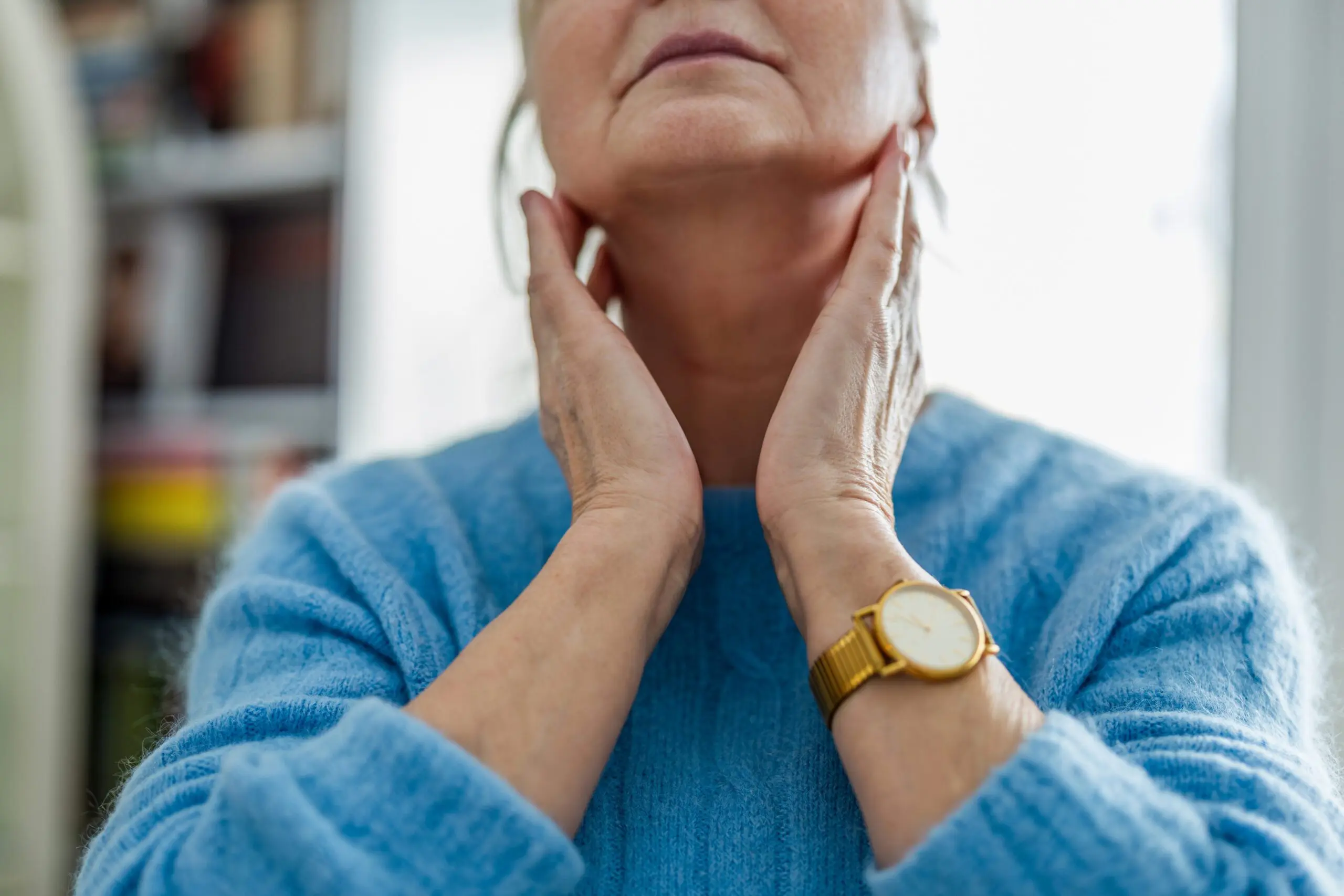 Woman giving herself a neck massage as part of a vocal warm-up