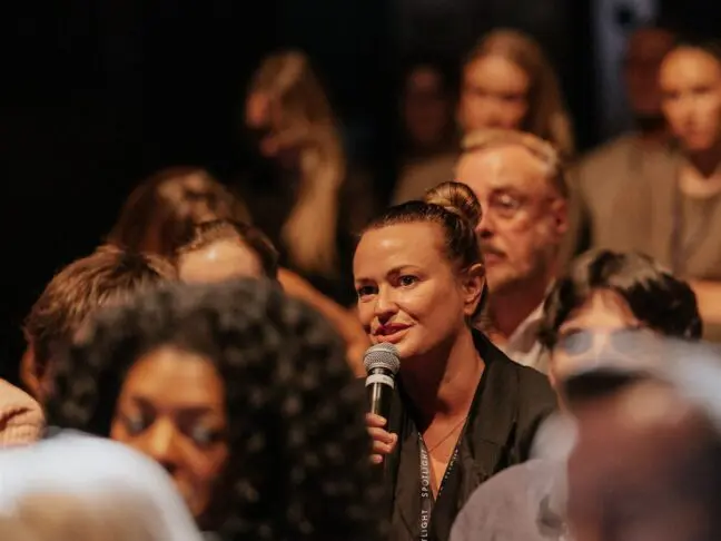 Woman speaking into a microphone at an event