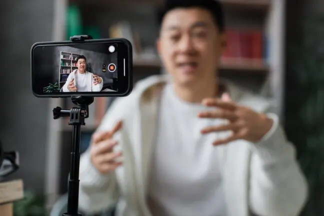 Man recording himself on a phone mounted on a tripod