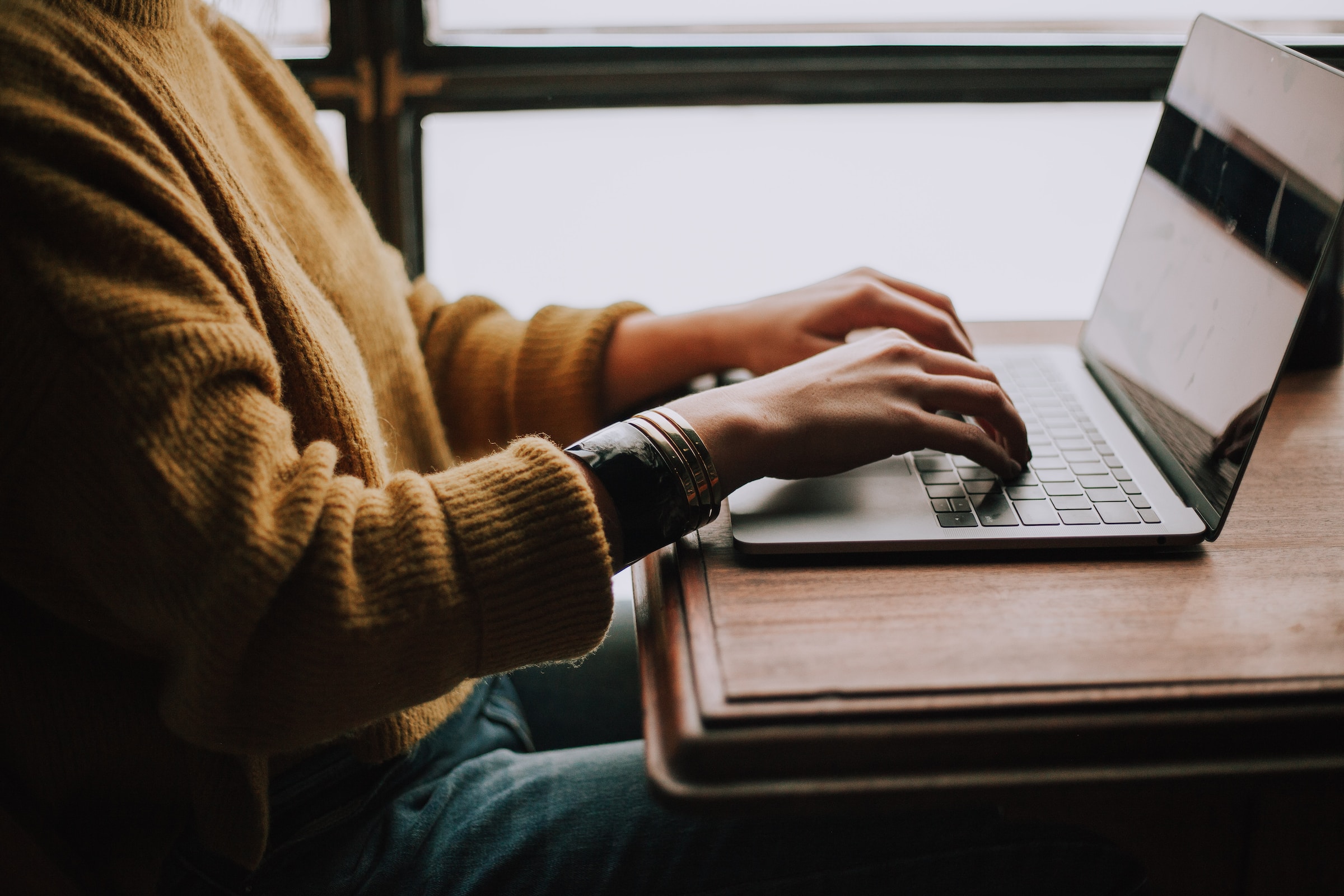 Someone typing on a laptop at a desk