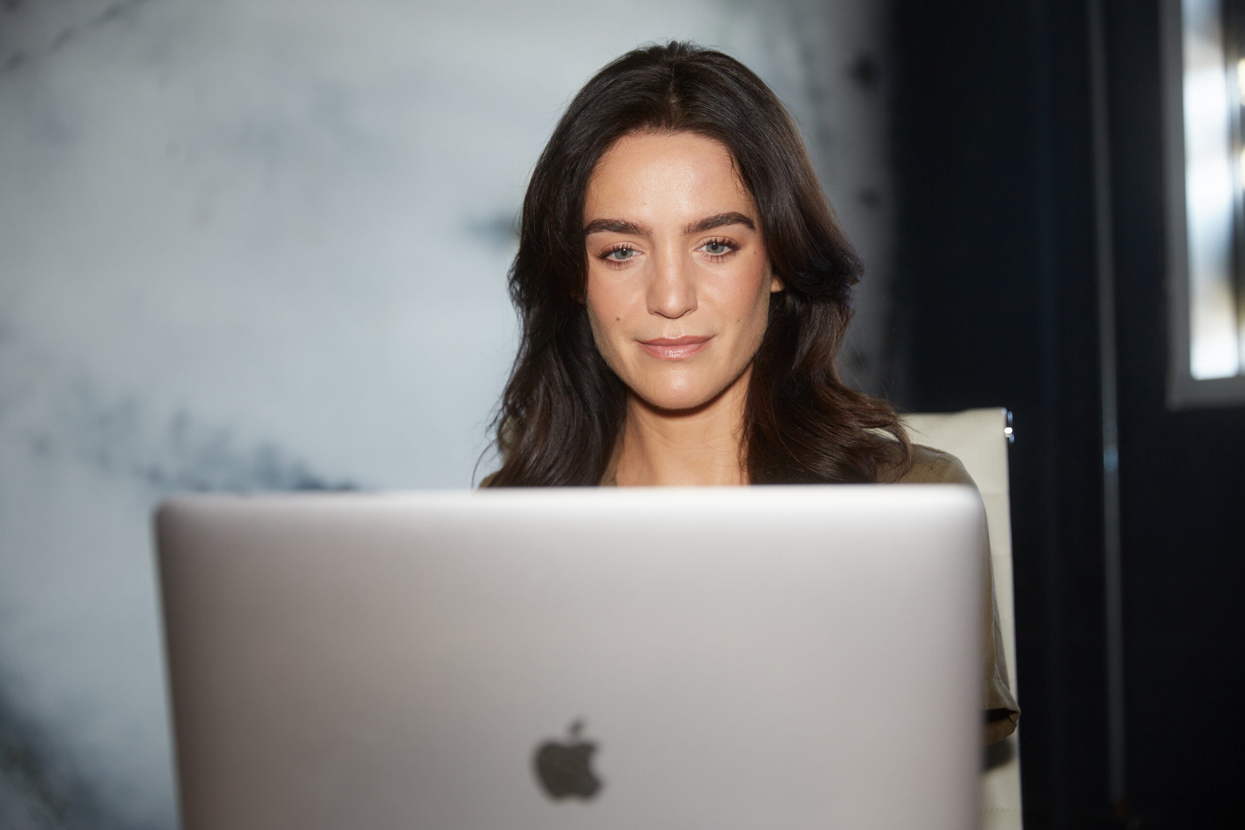 An actress sitting at her laptop looking for side jobs