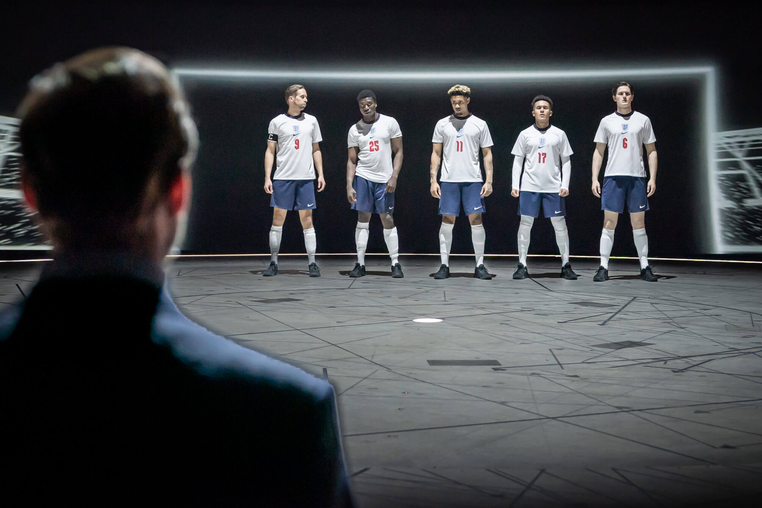 Footballers standing in a line before a goal in 'Dear England'