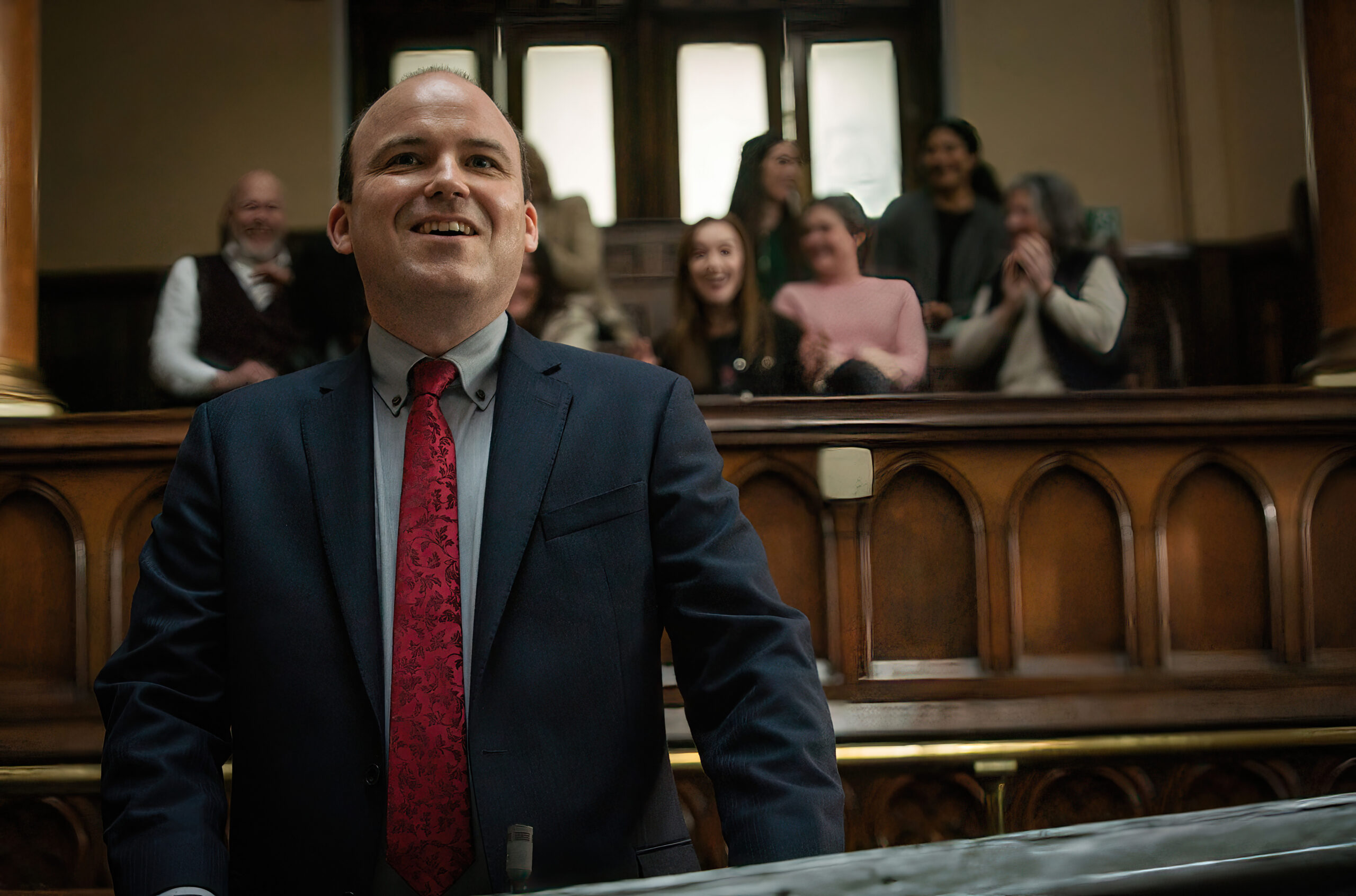 Rory Kinnear in 'Bank of Dave' smiling in a courtroom.