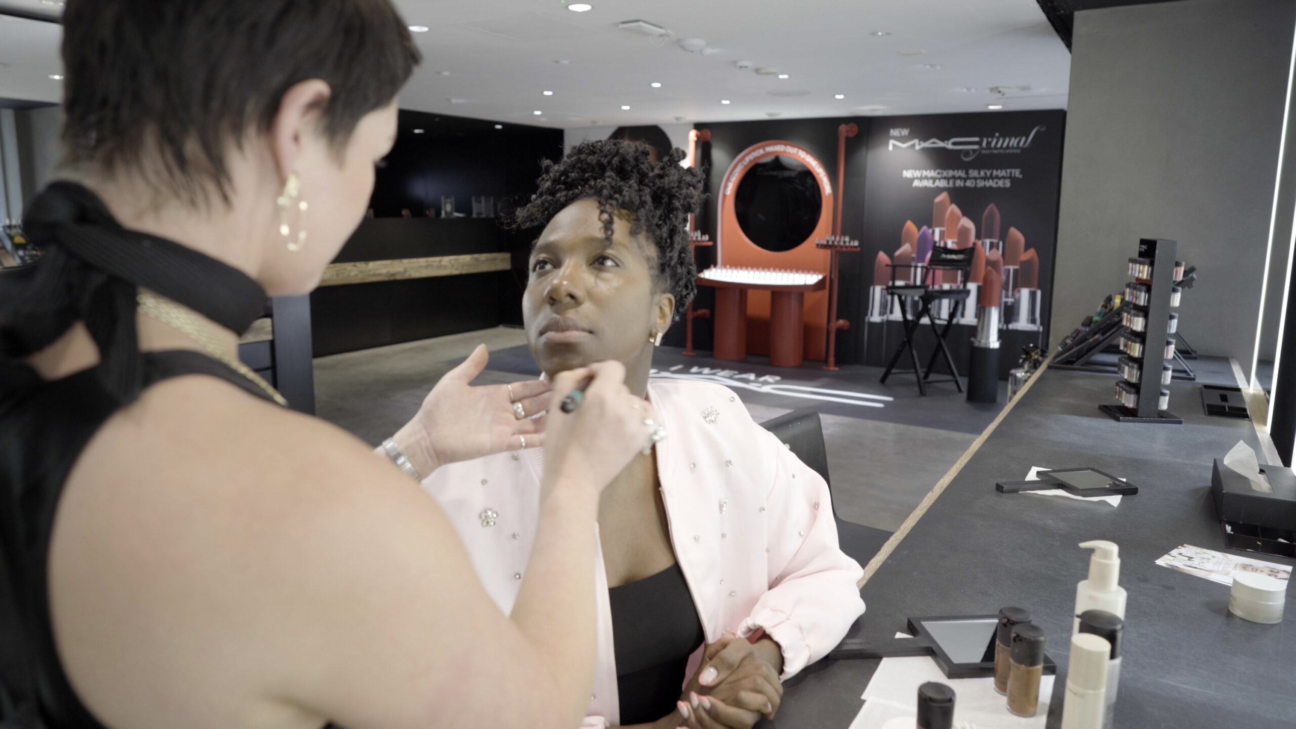 A performer of colour getting her make-up done in a MAC store