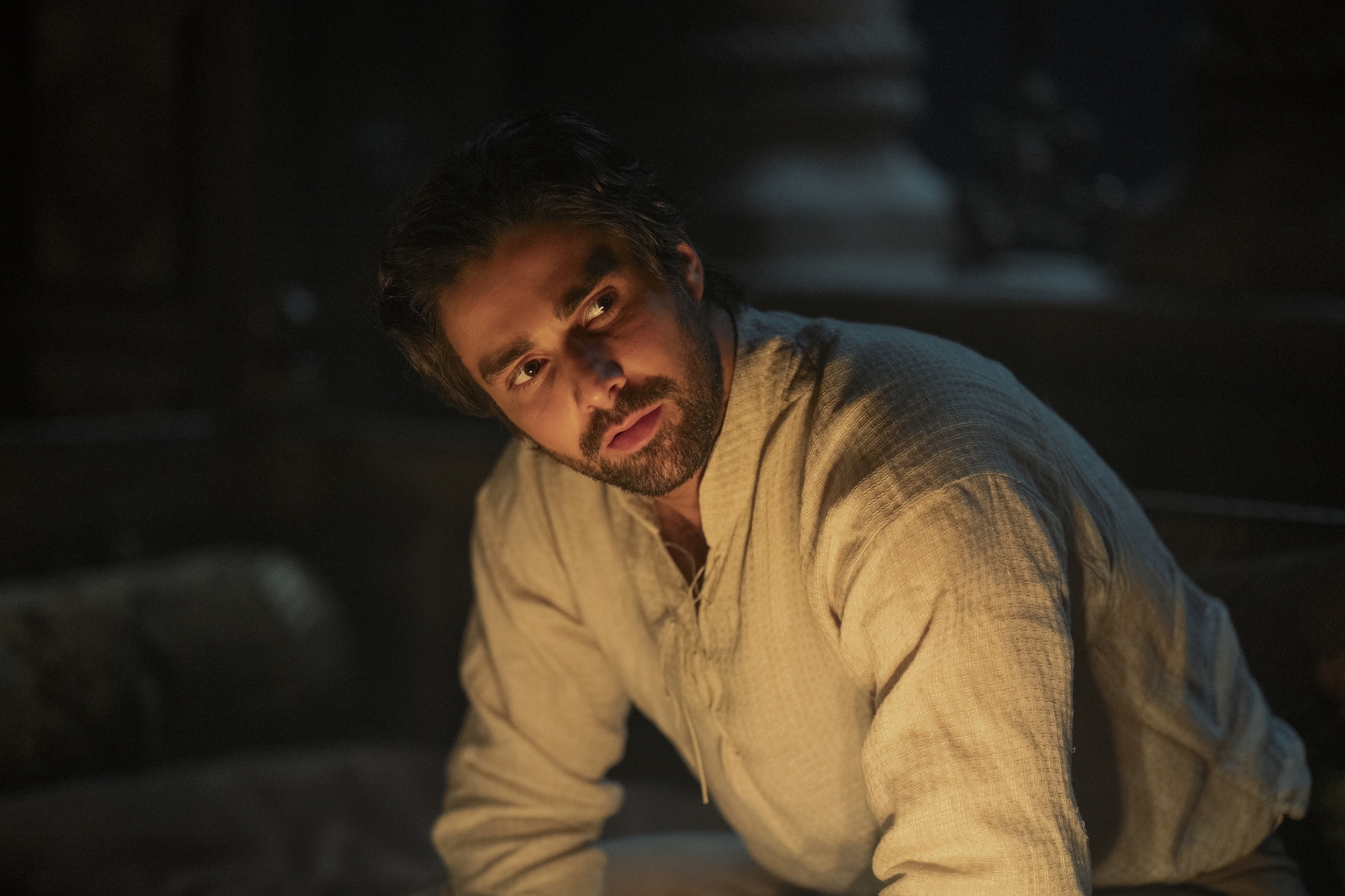 Fabien Frankel as 'Ser Criston Cole' in 'House of the Dragon' sitting in firelight