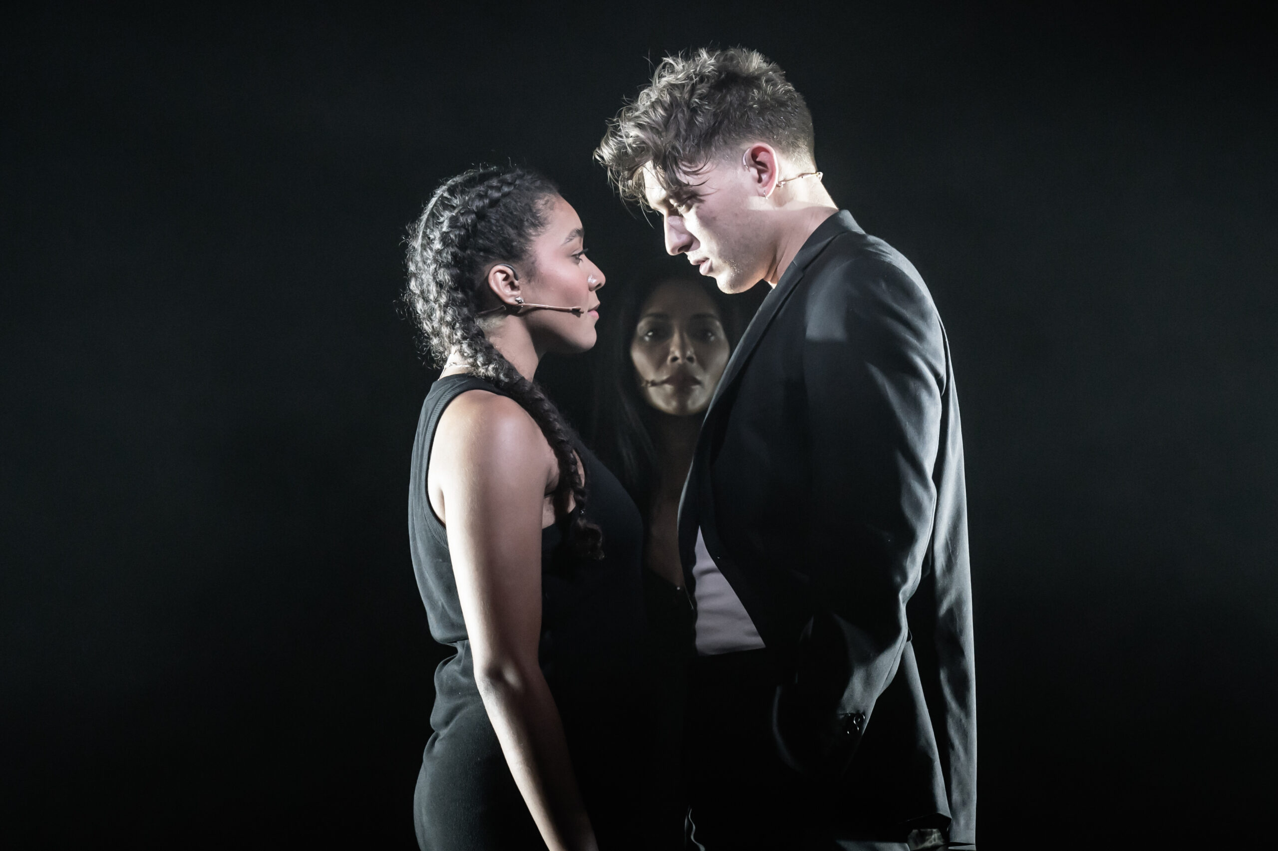 Tom Francis standing across from Grace Hodgett Young while Nicole Scherzinger watches from behind them in 'Sunset Boulevard'