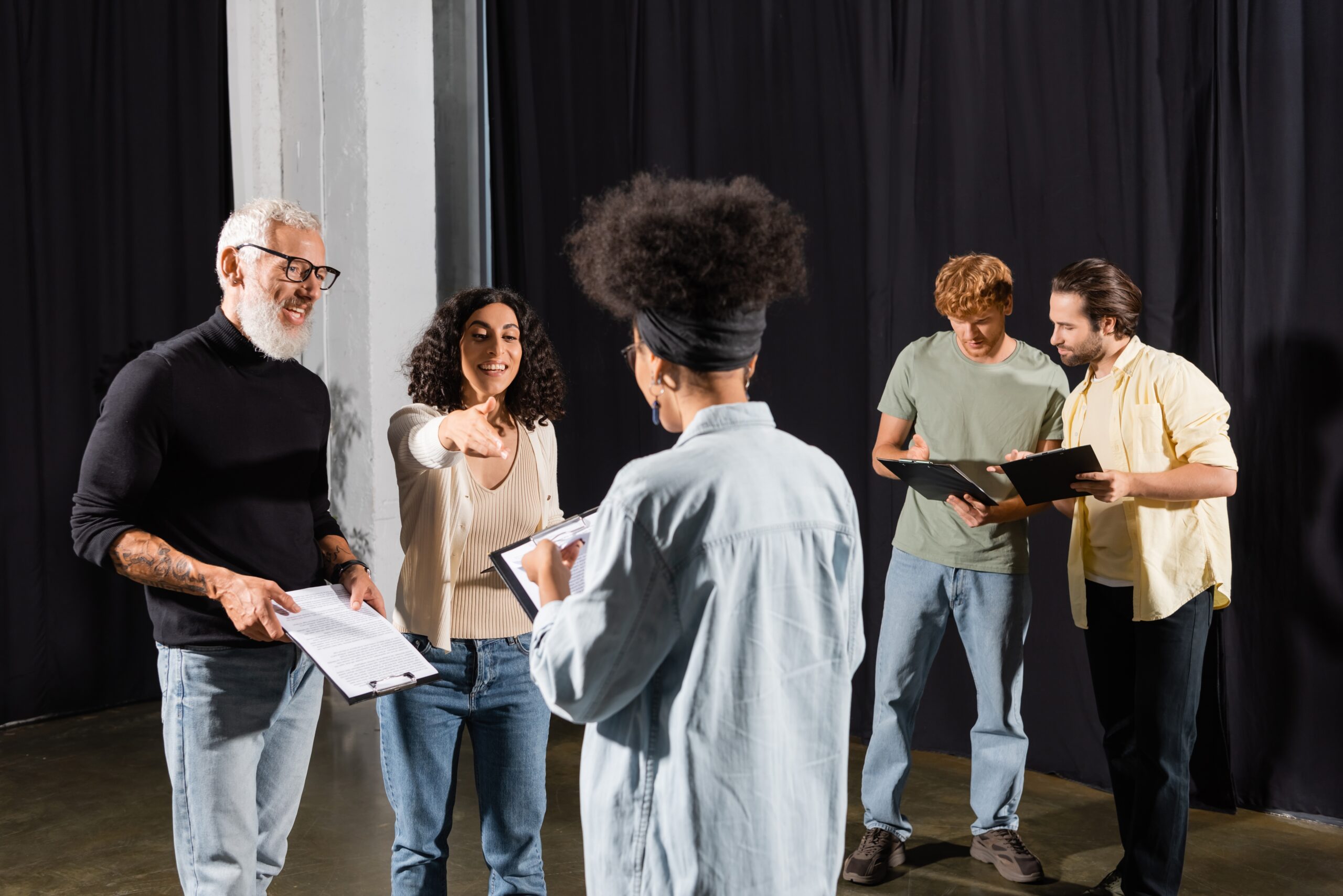 A group of people with scripts talking to each other