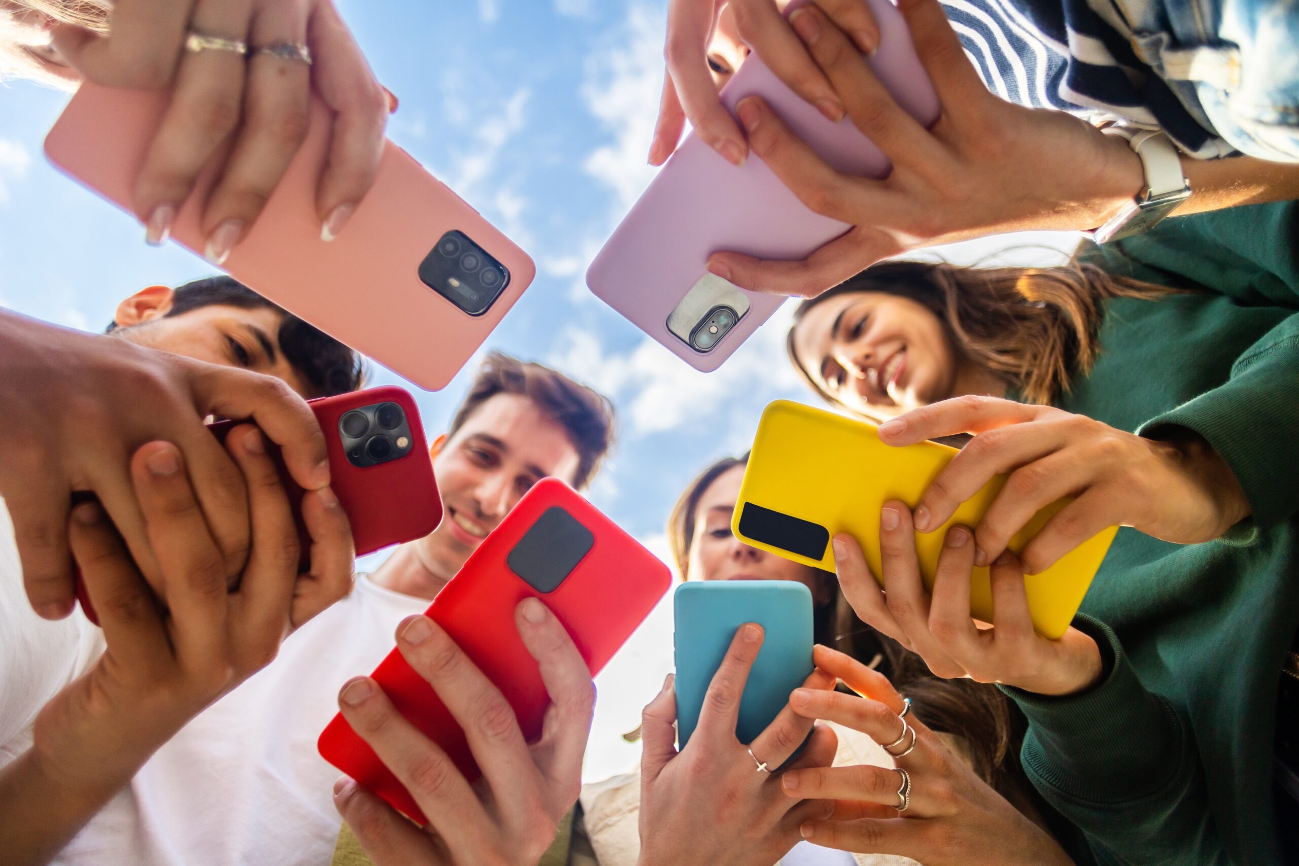 A group of people looking down at their phones held vertically