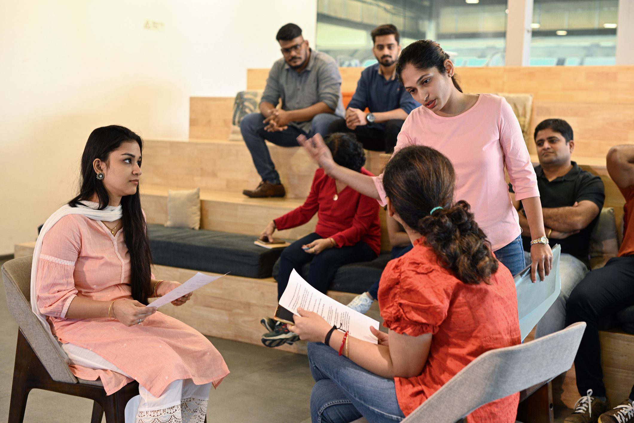 Acting teacher helping a female student with script in her hand in an acting class in a non-conventional classroom