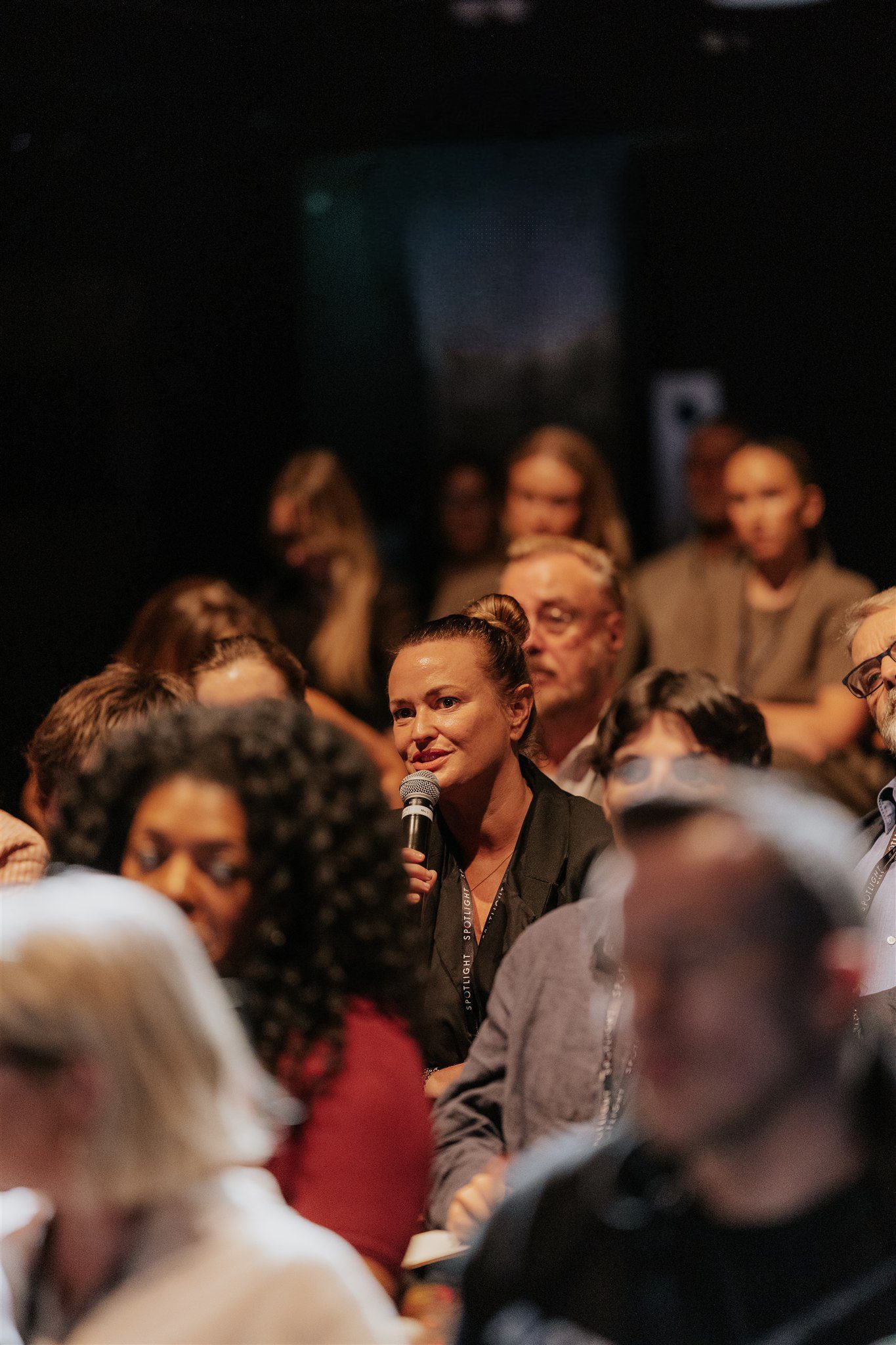 Crowd of people with a lady holding a mic