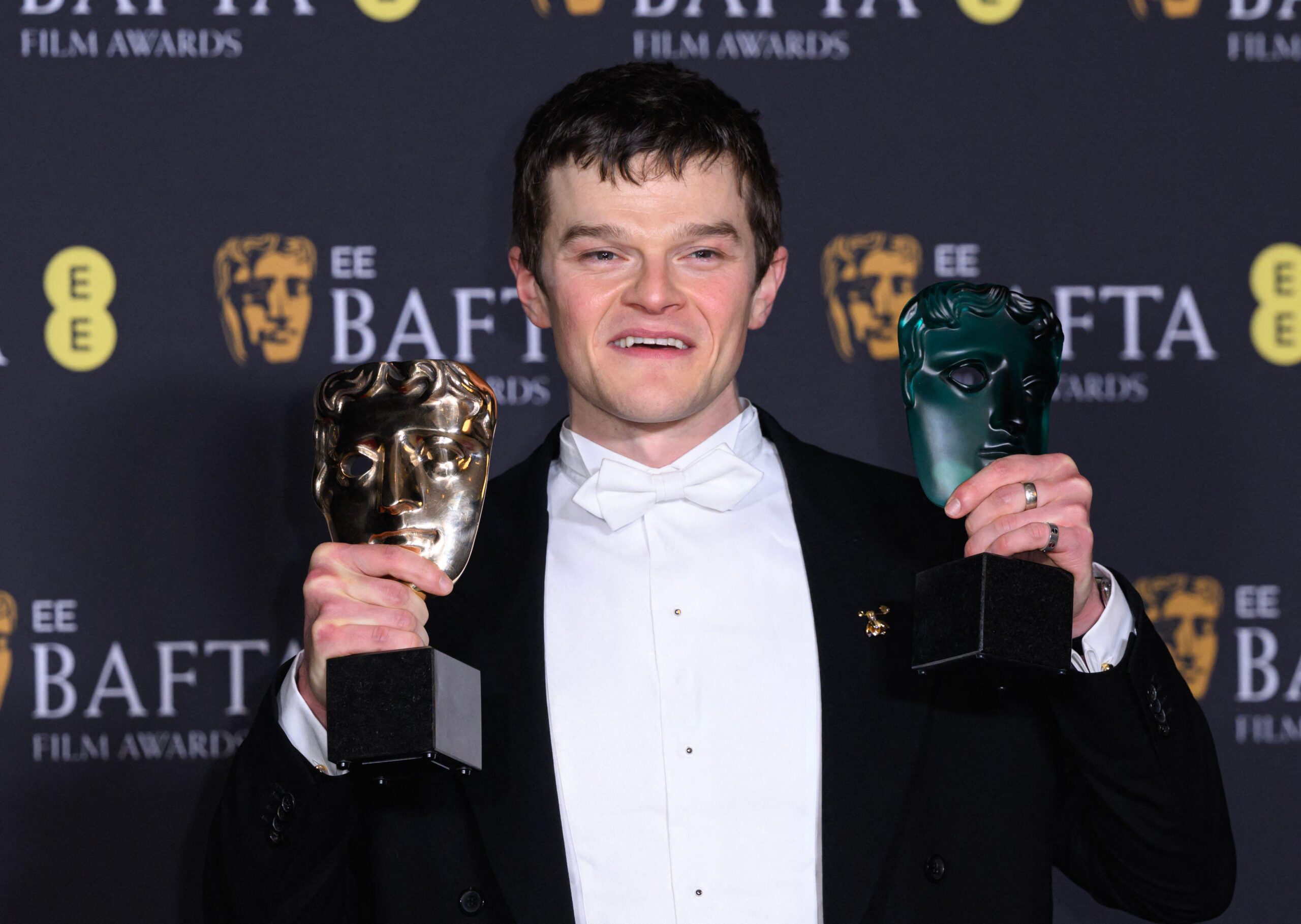 Robert Aramayo holding up his two BAFTA awards at the 2026 ceremony