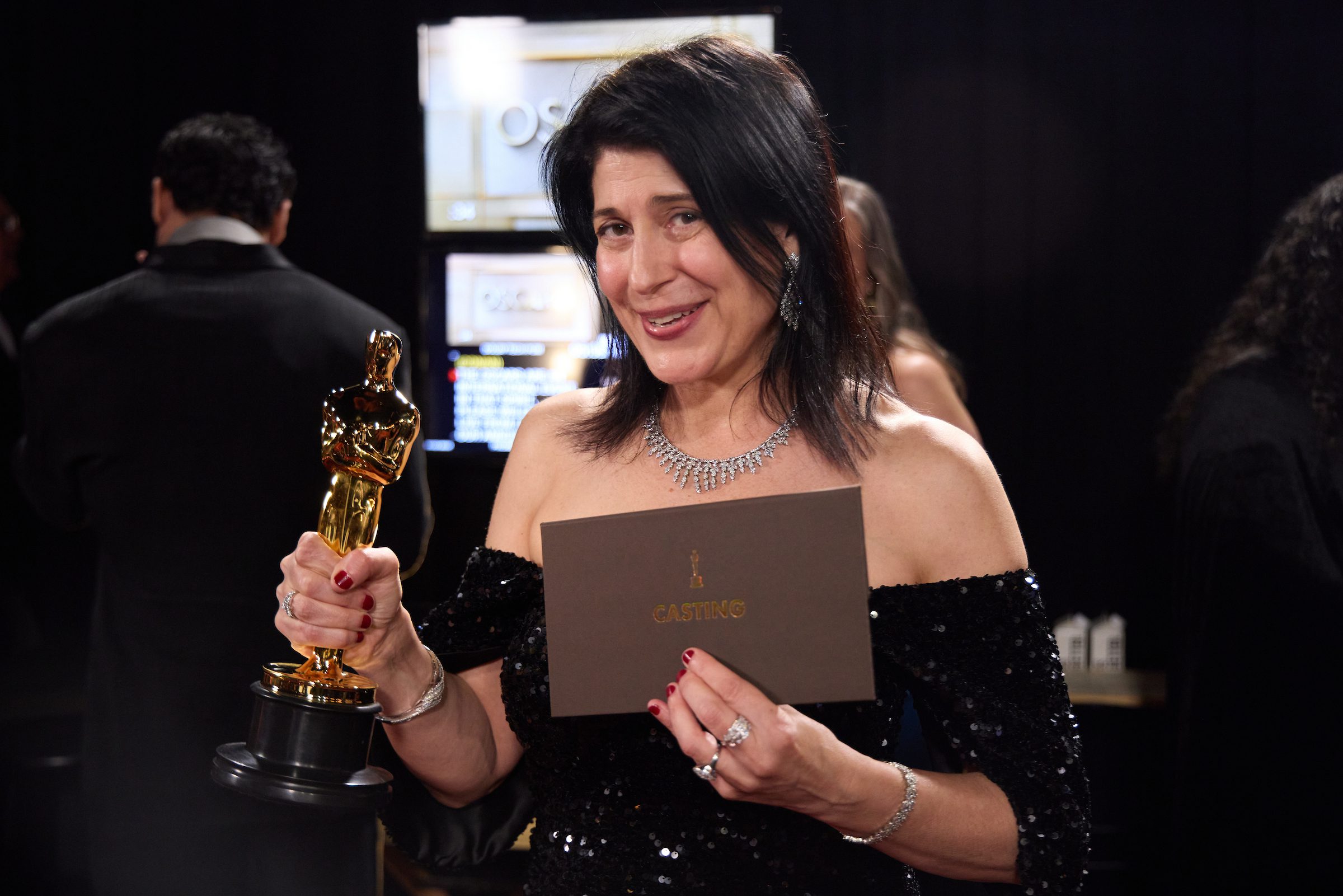 Cassandra Kulukundis posing backstage with her Oscar award for Best Casting