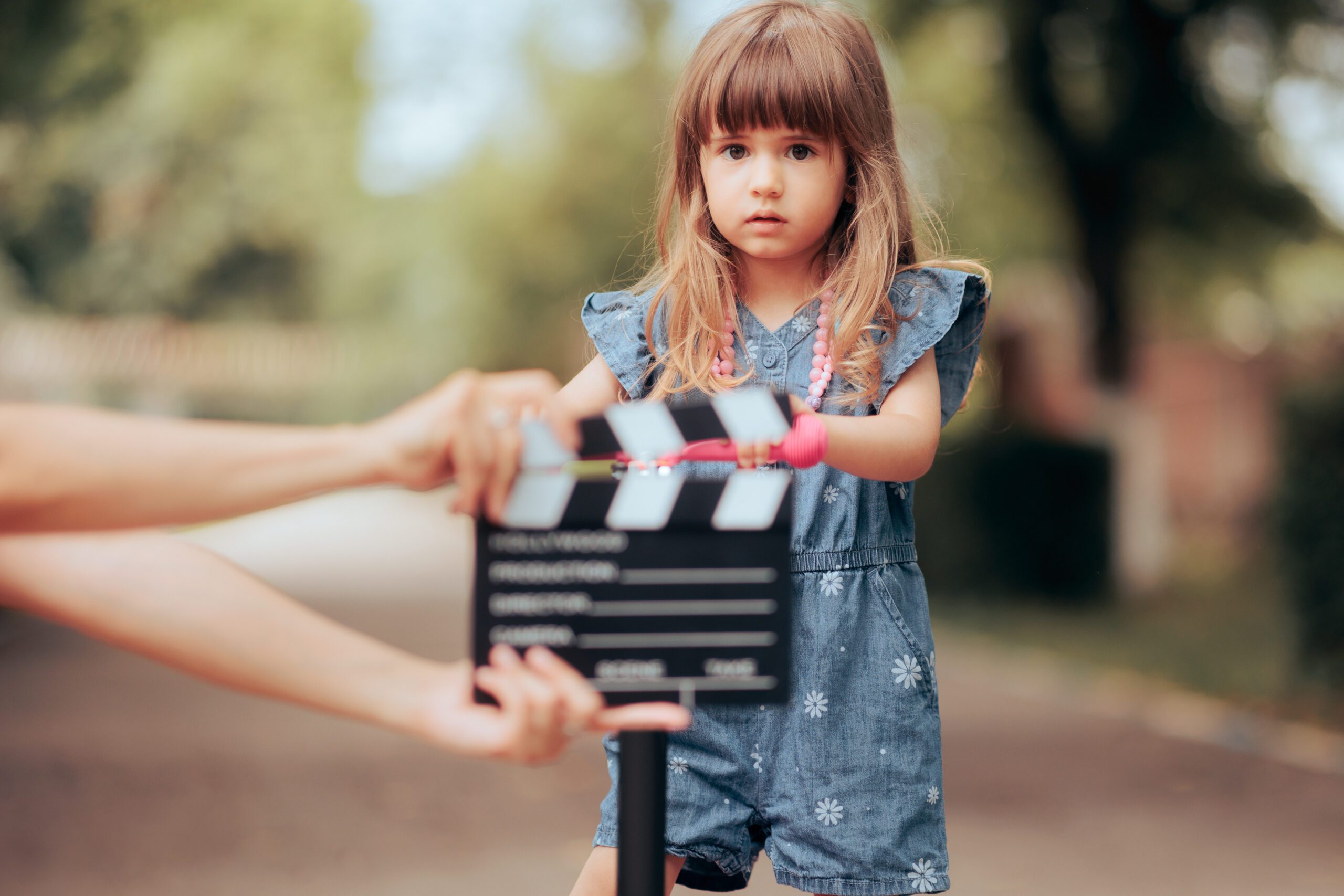 Young performer looking at a clapperboard