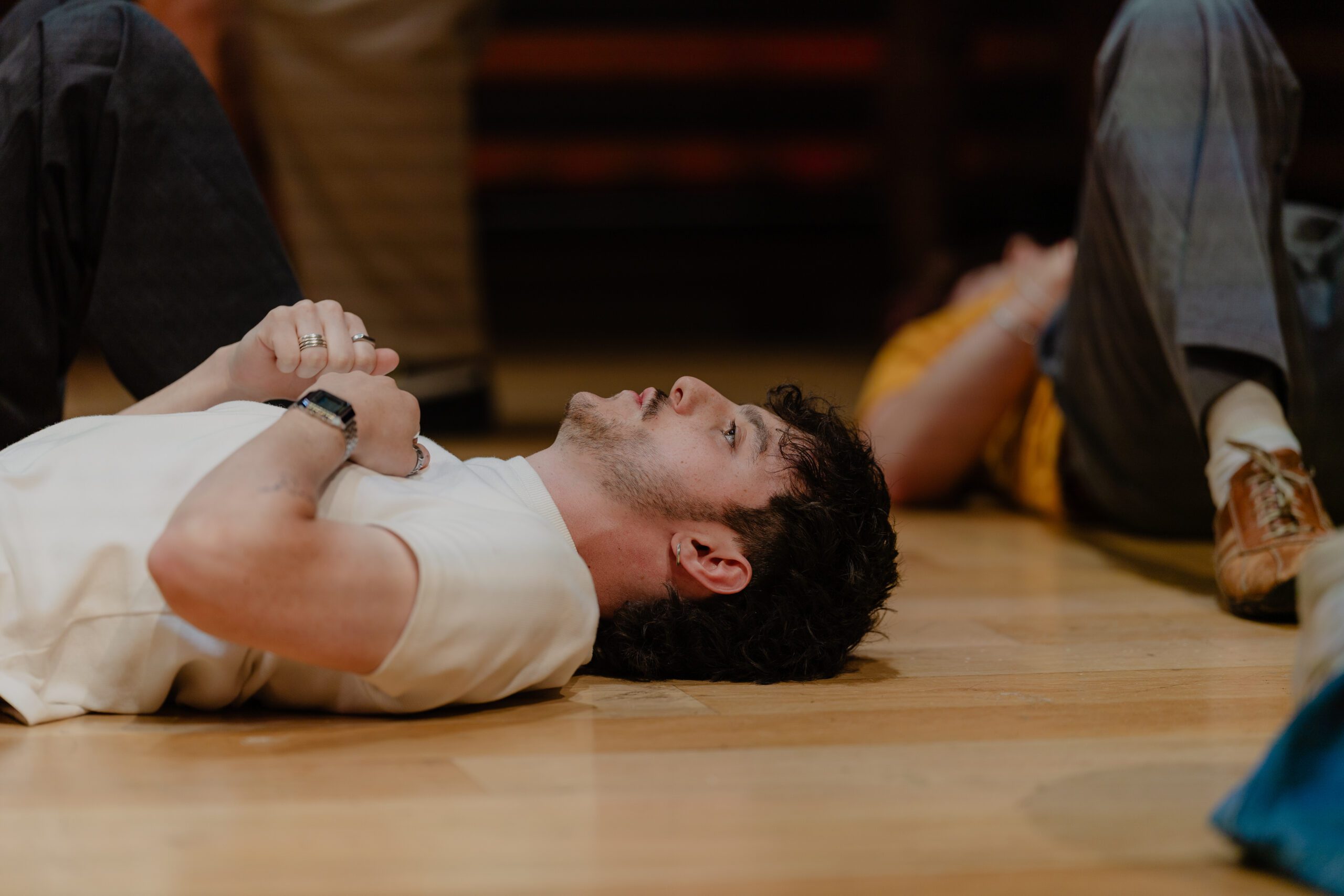 An actor lying on their back to calm themselves before a performance