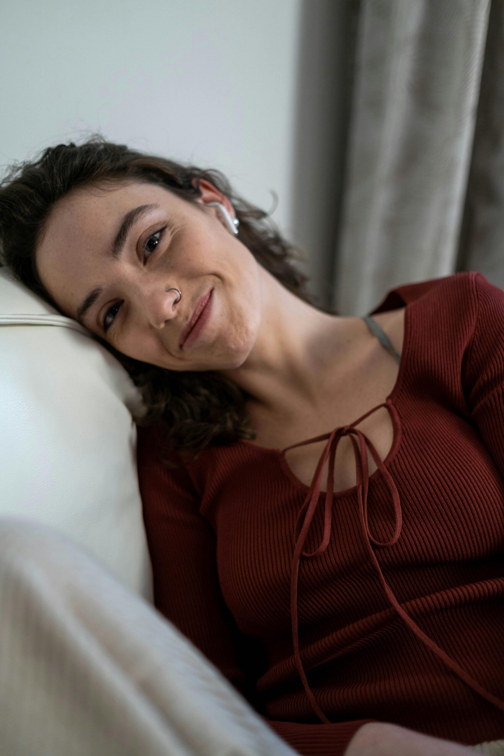 Woman with red top leaning on pillow