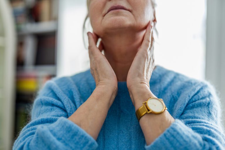 Woman giving herself a neck massage as part of a vocal warm-up