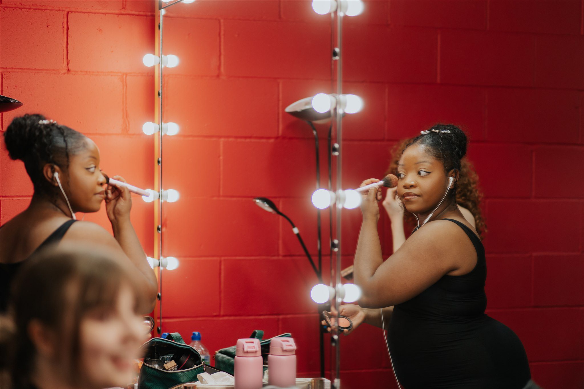 Lady putting on makeup in front of mirror